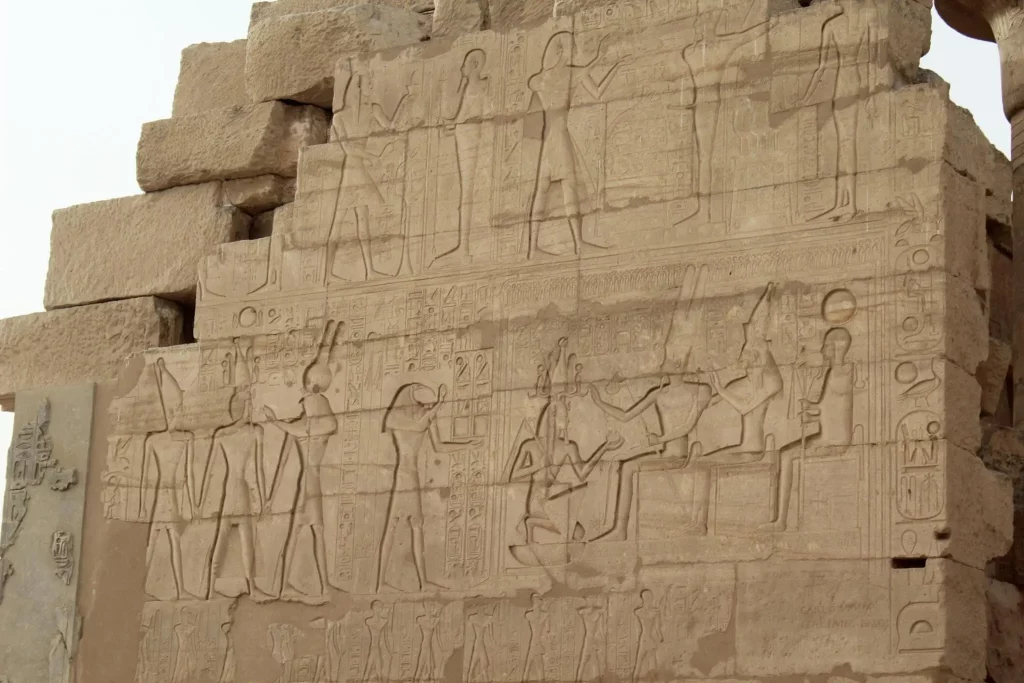 Man kneeling in front of the Theban triad in the mortuary temple of Ramesseum in Luxor in Egypt stock photo