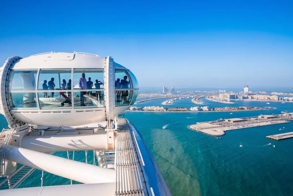 Ain Dubai cabin with people admiring beautiful Dubai skyline and Palm Jumeirah. The biggest ferris wheel in the world. island. The biggest ferris wheel in the world.
