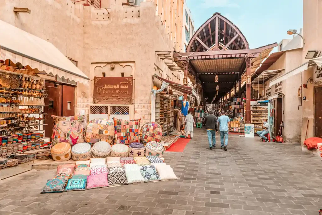 Old Bur Dubai souk market in Creek district. Sellers and merchants with goods, textiles and souvenirs