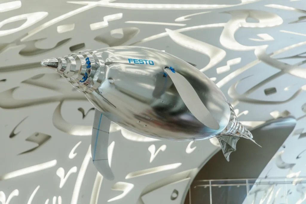 An inflated balloon with propellers in the form of a dolphin flies inside the Museum of The Future