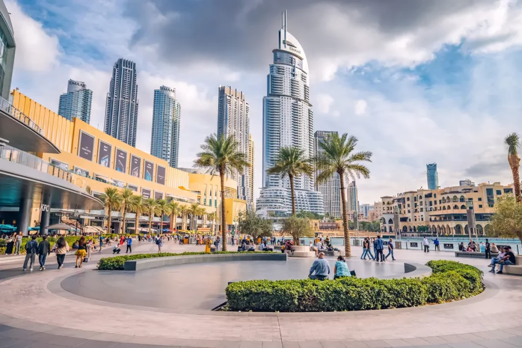  Crowd of tourists walking at the square near the entrance to Dubai Mall and on promenade embankment Dubai Mall and Shopping Guide
