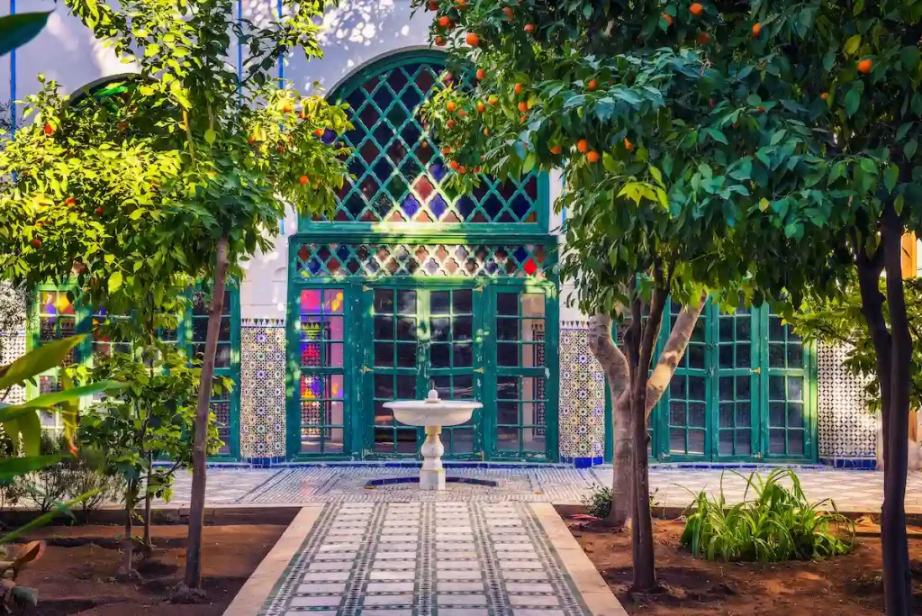 Small white fontaine among orange trees of Jardin Majorelle in Marrakech, Morocco