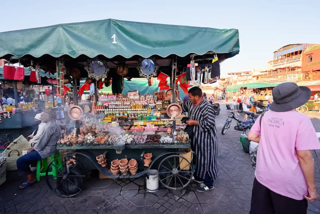 a view of the Jemaa el Fna square with people, shops