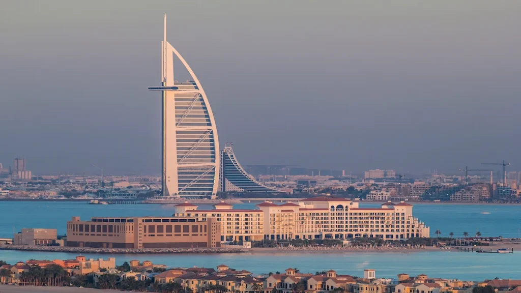Dubai skyline with villas and Burj Al Arab during sunset aerial timelapse. Top view from above on palm jumeirah.