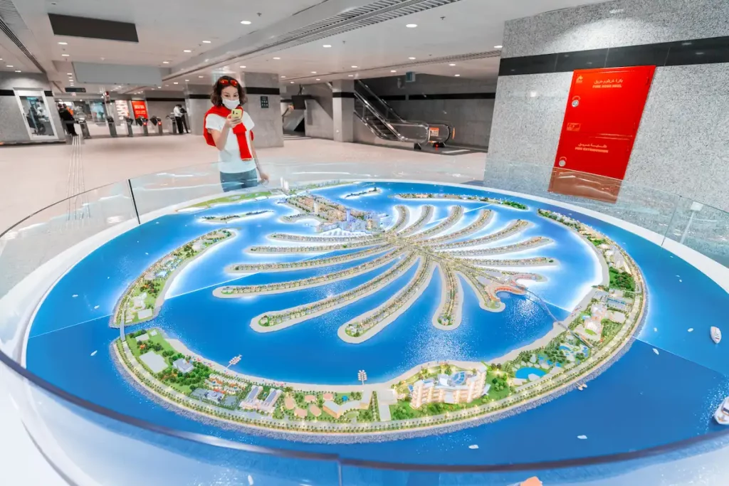 Woman tourist at the plan of artificial island of Palm Jumeirah at the monorail station - popular tourist destination