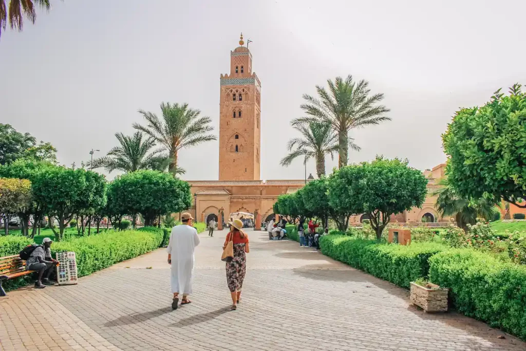Tourist and tour guide exploring Marrakech and Koutoubia Mosque