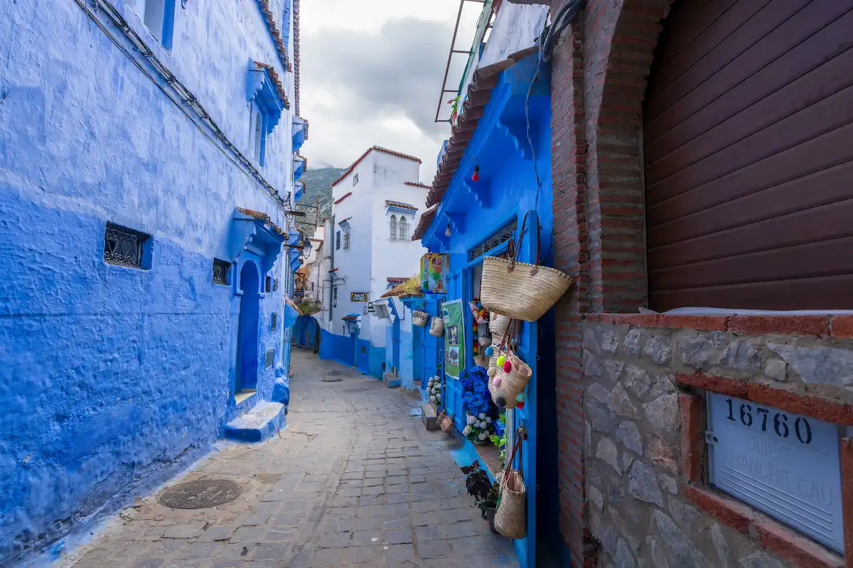  handicraft shop displaying colorful ceramic plates and mirrors in the blue-painted streets. 