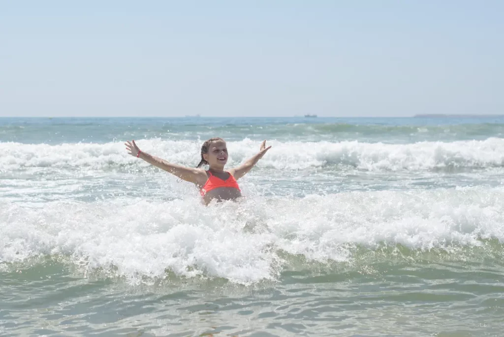 teen girl playing near the ocean