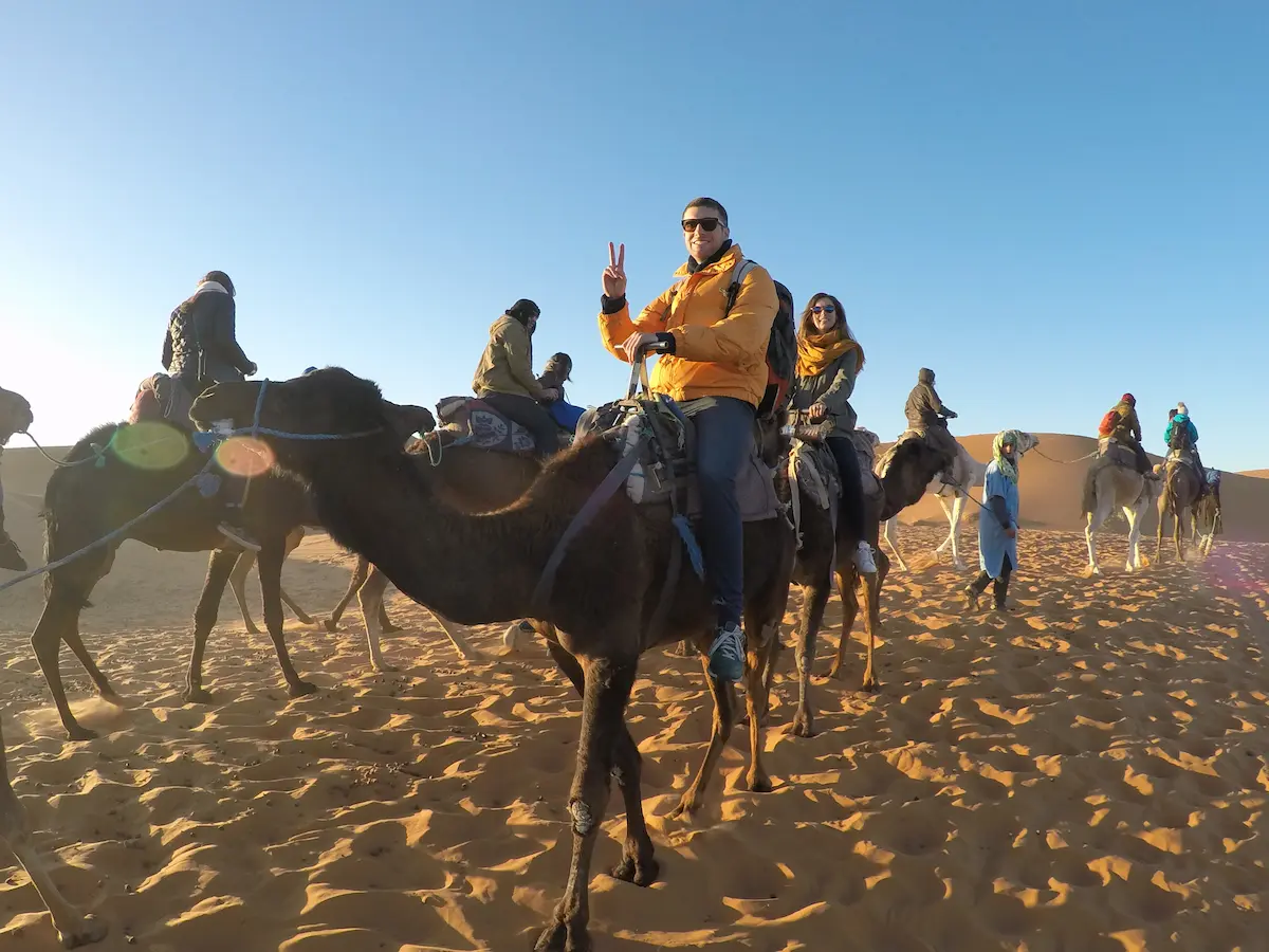 Merzouga, Morocco Spring 2017: A couple on top of dromedaries in Merzouga Dunes Erg Chebbi
