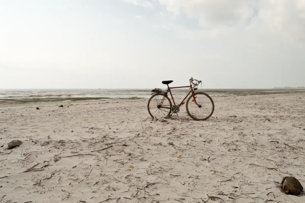 Red and white racing bike on the white sand of bamburi beach in Mombasa, Kenya