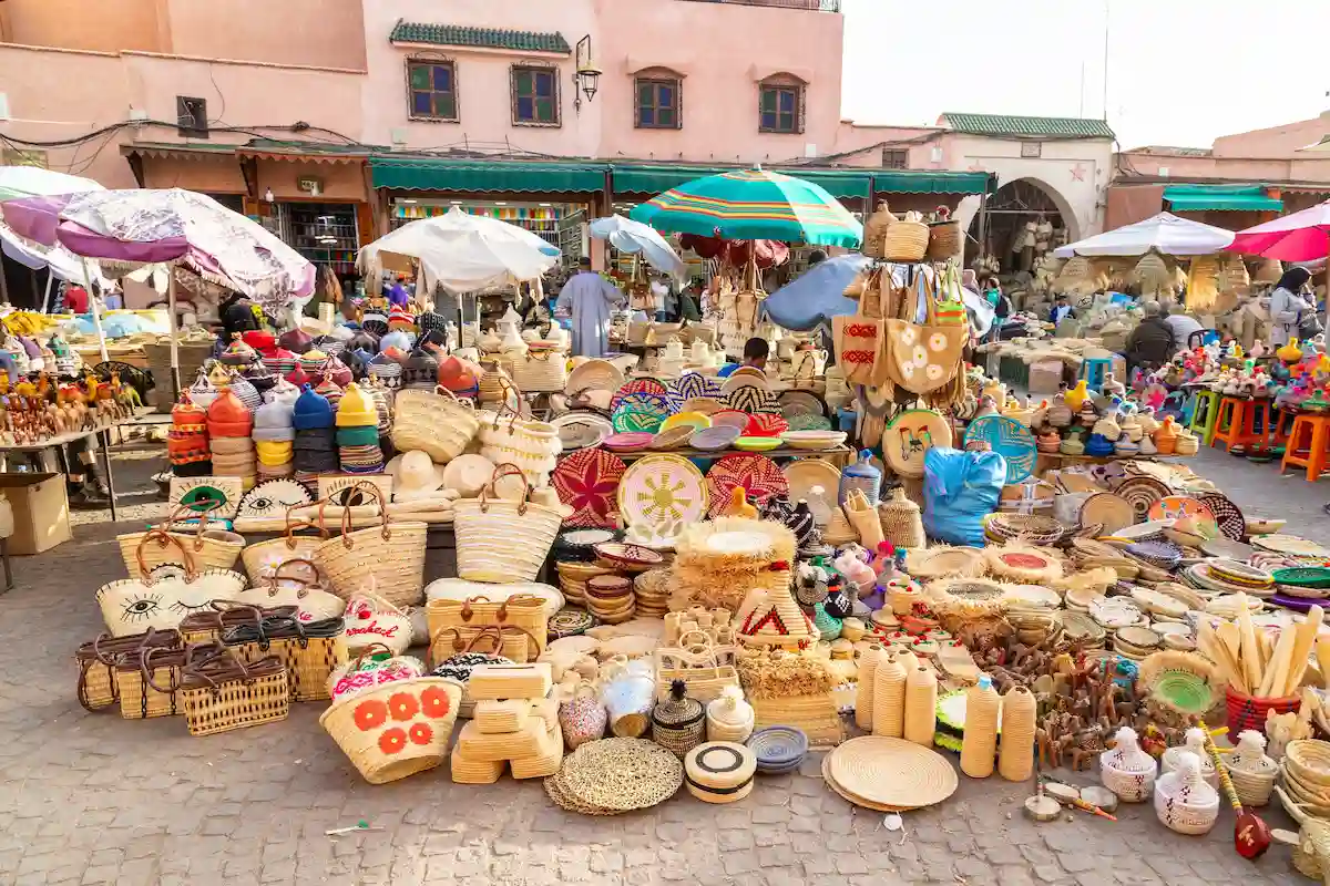MARRAKESH, MOROCCO - 3RD NOV 22: A market stall in the Medina of Marrakesh selling wicker baskets, bags, bowls and other items. People can be seen near the stalls