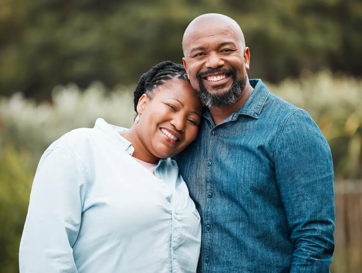 Mature black couple, portrait and happy in garden with hug, connection and love with care in summer. Senior man, woman and smile in backyard with embrace, bonding and outdoor with sunshine in Kenya