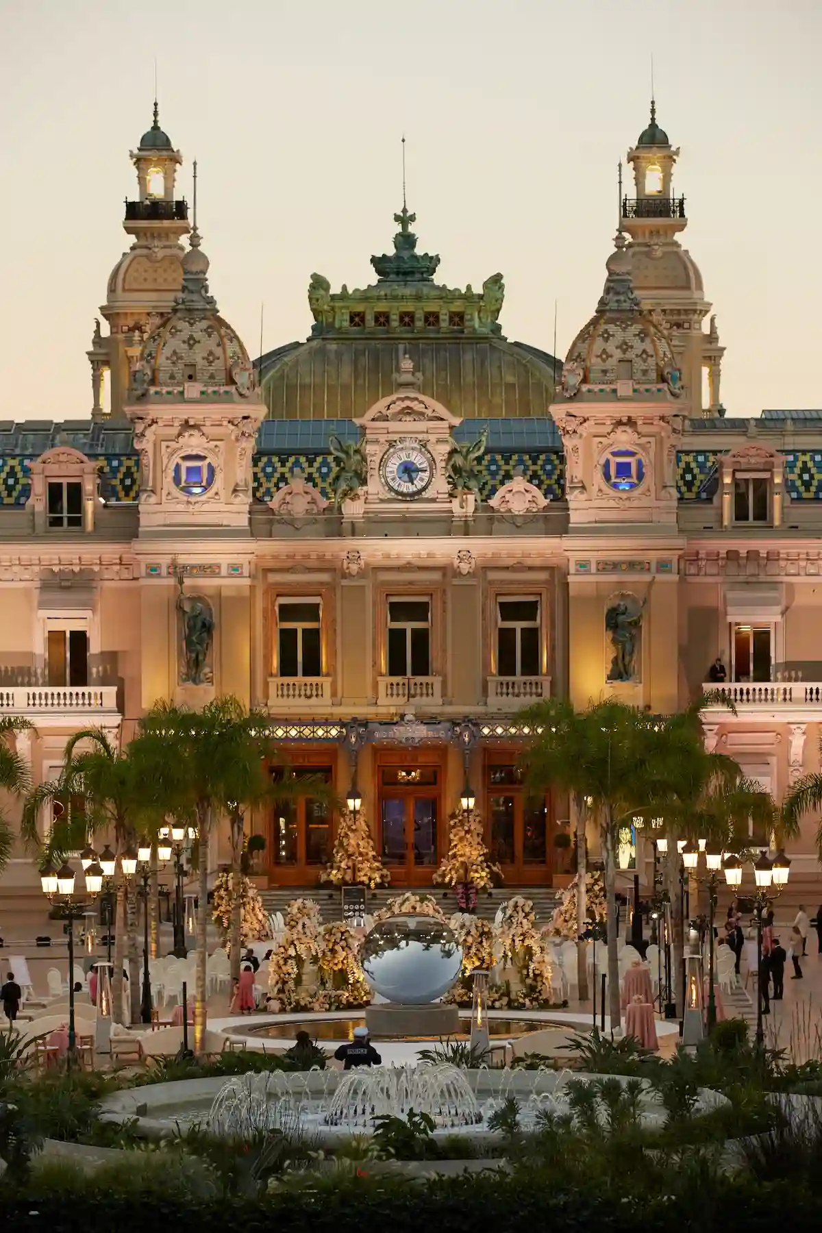 Monaco, Monte-Carlo, 21 October 2022: Square Casino Monte-Carlo at sunny day, a lot of luxury cars, Hotel de Paris, wealth life, tourists take pictures of the landmark, pine trees, blue sky, flowers