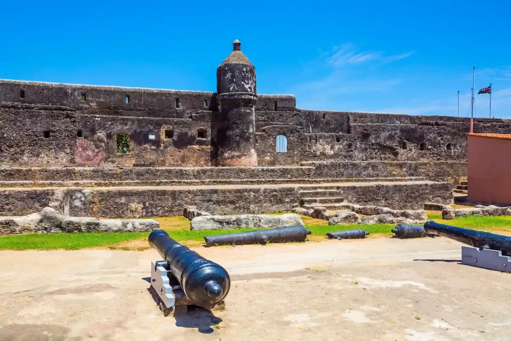 Bastion and loopholes in the thick ancient walls. Guns are on display in the fortress. Fort Jesus - medieval fortification in Mombasa, Kenya.