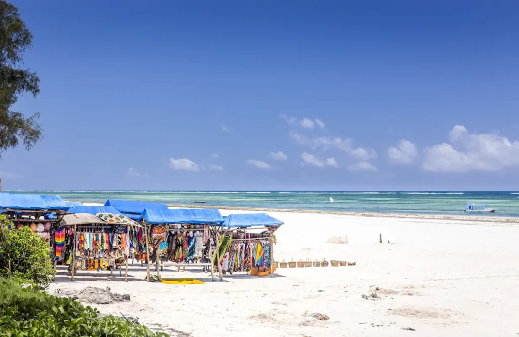 Amazing Diani beach seascape, white sand and wooden stall with colorful souvenirs, Kenya