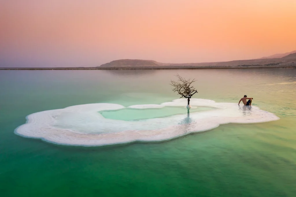 A bather relaxing on an island in the Dead Sea on a hazy morning