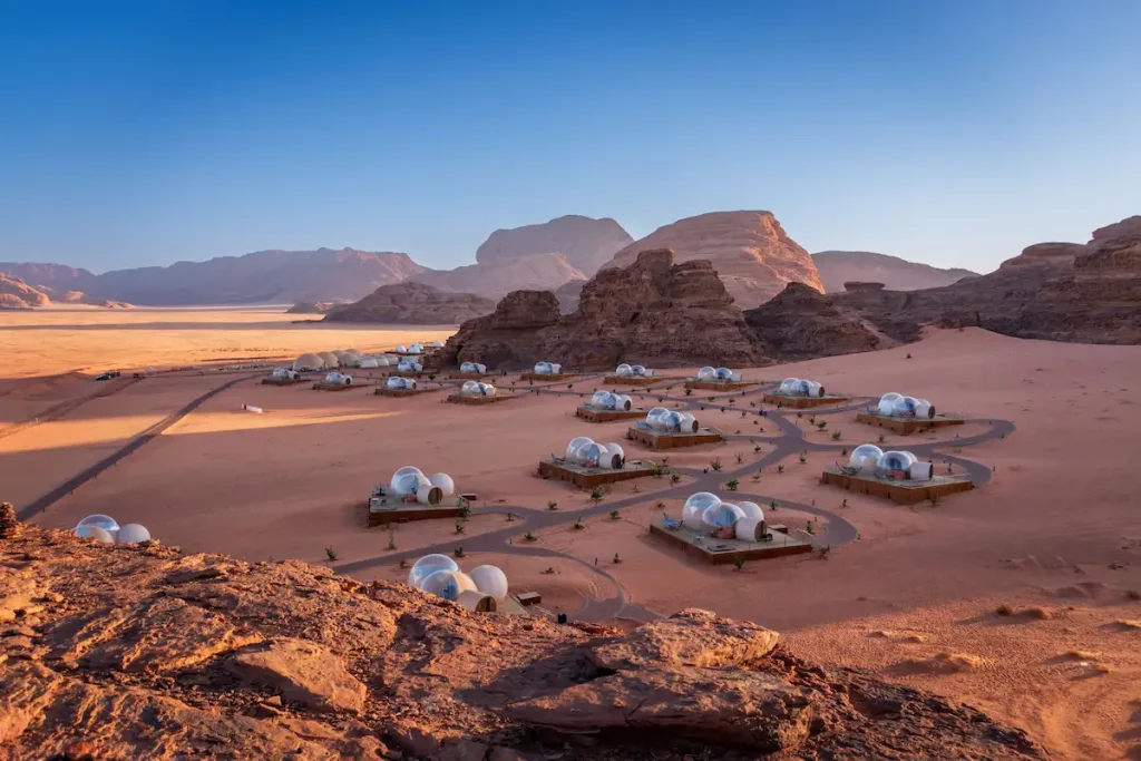 Scenic view of bubble tent camp at Wadi Rum desert in Jordan at sunrise against blue sky
