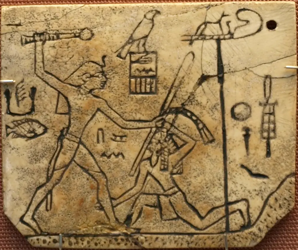 Ivory labels of Den depicts him beating a foe with his stick