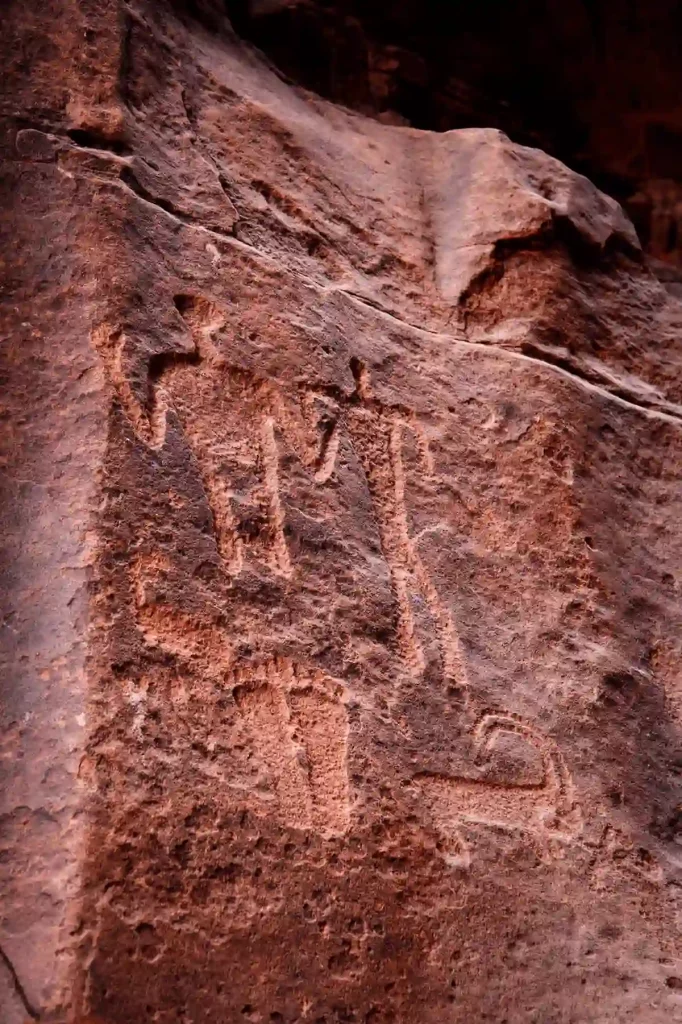 Petroglyphs in Khaz'ali Canyon walls depicting humans, footprints and antelopes from Thamudic times, Wadi Rum, Jordan