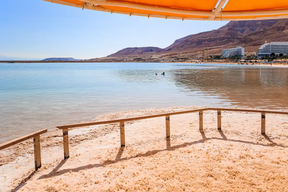 The Dead Sea is an endorheic, very salty lake in the Middle East. Coast of Israel. Evaporated salt forms сrystals on the surface of the water.