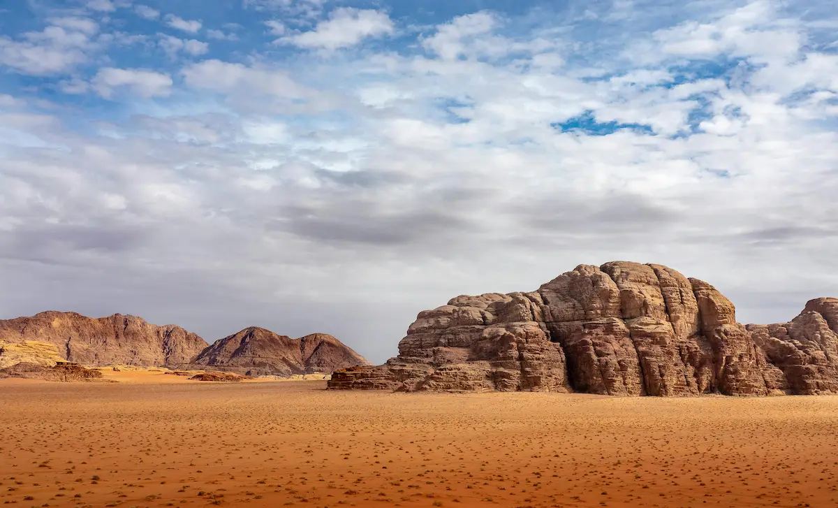 A Rock Mountains in a Desert Under Cloudy Blue Sky