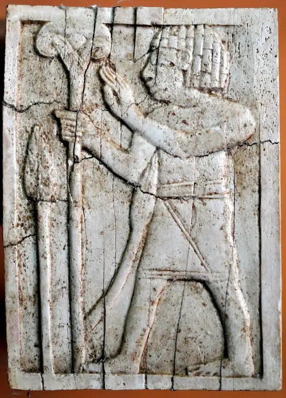 An Egyptian-looking man holds a lotus flower on a long stalk